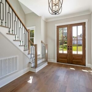 Elegant and spacious house entrance featuring wooden doors and staircase.